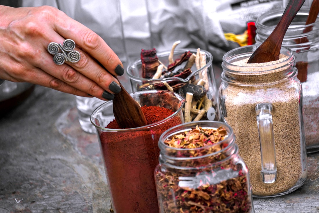 Herbs and powders being weighed out of glass apothecary jars